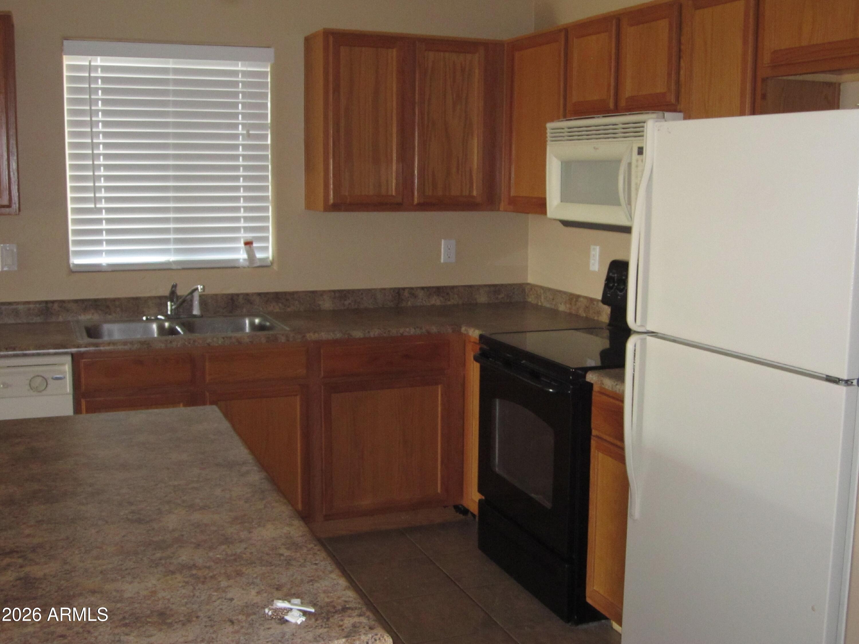 18671 North Madison Road Maricopa, AZ 85139 - Photo 13 of 27 a kitchen with stainless steel appliances granite countertop a refrigerator and a sink