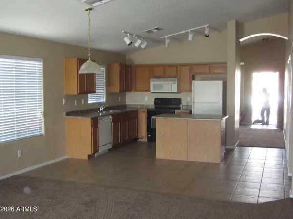 a view of a kitchen with kitchen island granite countertop wooden cabinets a sink and a window