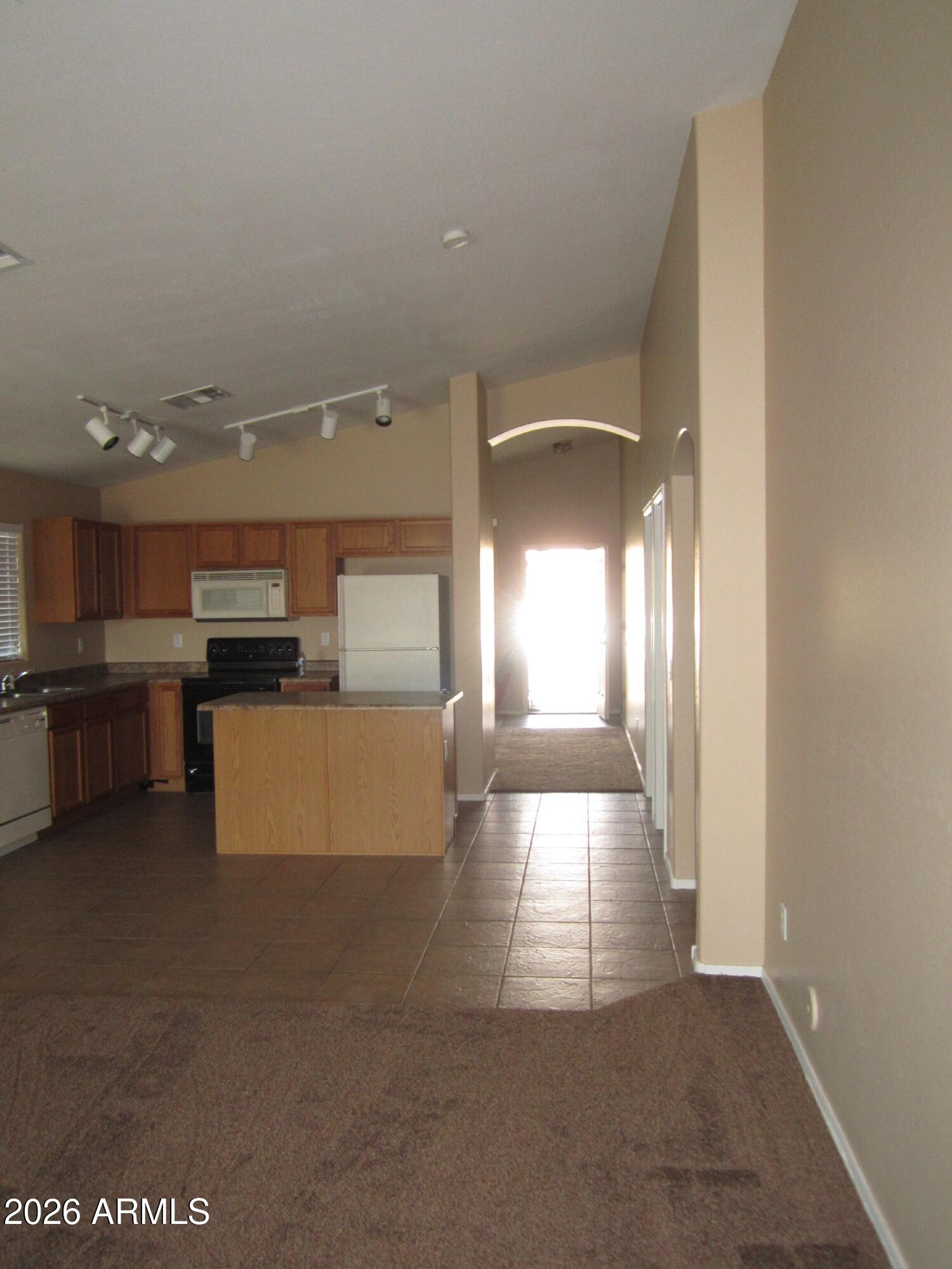 18671 North Madison Road Maricopa, AZ 85139 - Photo 5 of 27 a view of a kitchen with kitchen island and stainless steel appliances