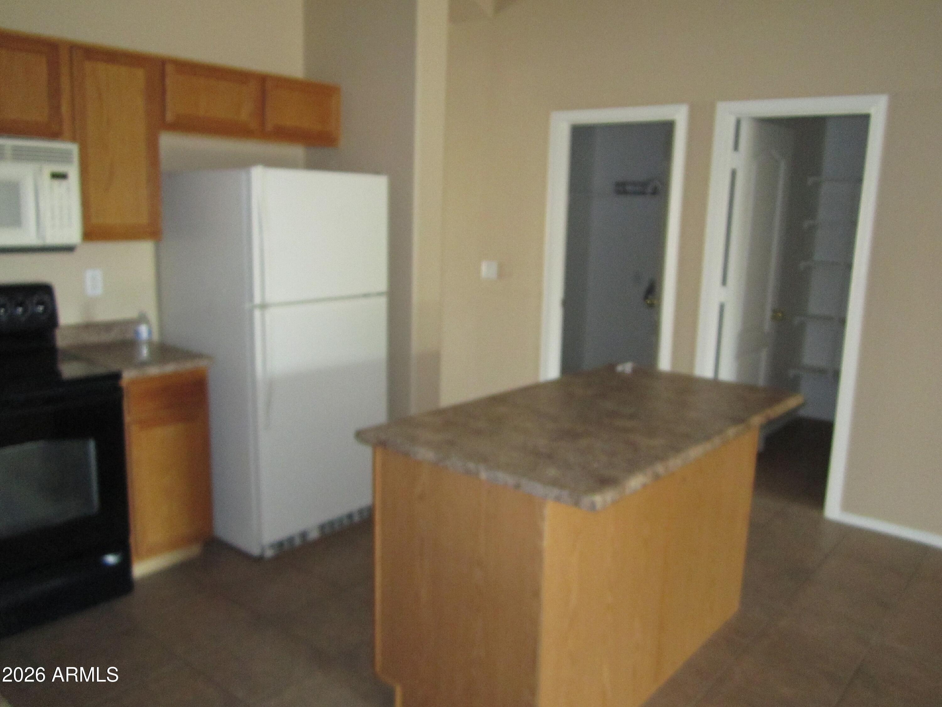 18671 North Madison Road Maricopa, AZ 85139 - Photo 7 of 27 a kitchen with stainless steel appliances granite countertop cabinets and refrigerator