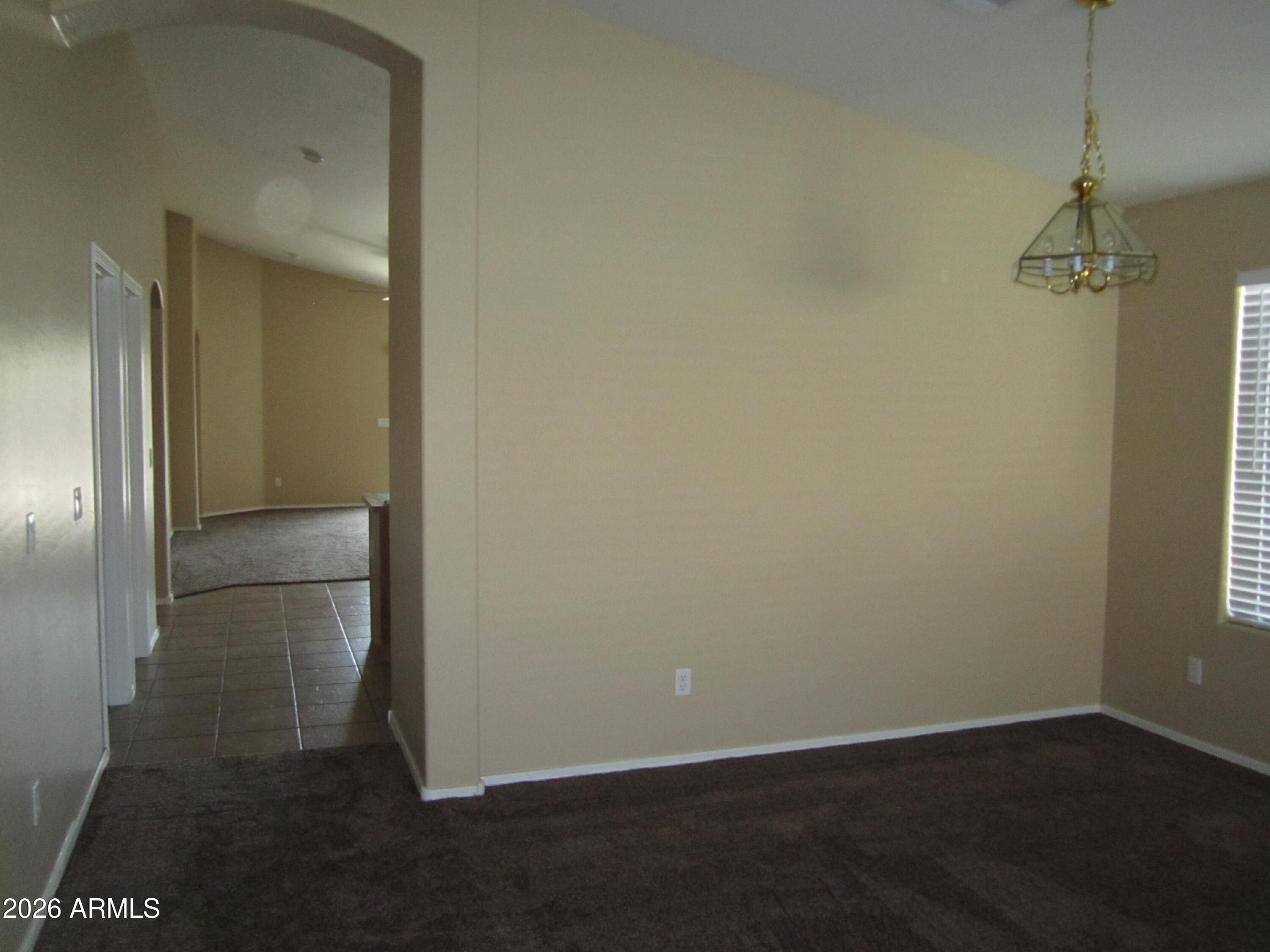 18671 North Madison Road Maricopa, AZ 85139 - Photo 10 of 27 an empty room with wooden floor