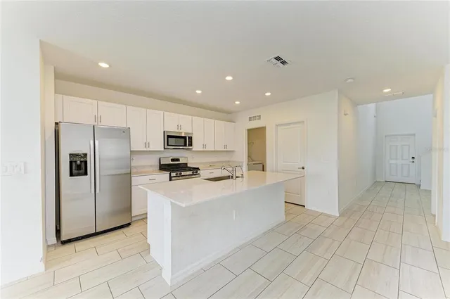a kitchen with stainless steel appliances a refrigerator sink and microwave