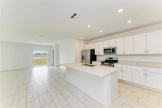 a kitchen with stainless steel appliances a refrigerator sink and microwave