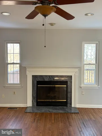 wooden floor in an empty room with a chandelier