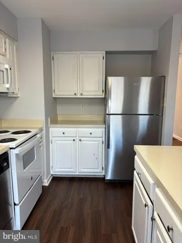 a kitchen with stainless steel appliances a refrigerator a stove a sink and a large window