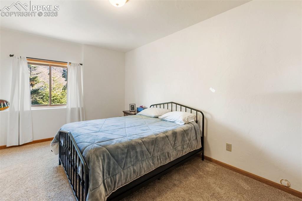 9110 Mountain Road Cascade, CO 80809 - Photo 31 of 49 a bedroom with a bed and window