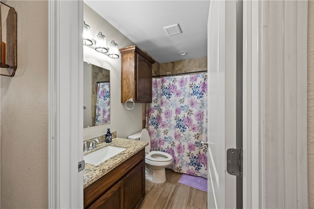 200 West 4th Street Alice, TX 78332 - Photo 14 of 19 a bathroom with a granite countertop sink toilet and shower