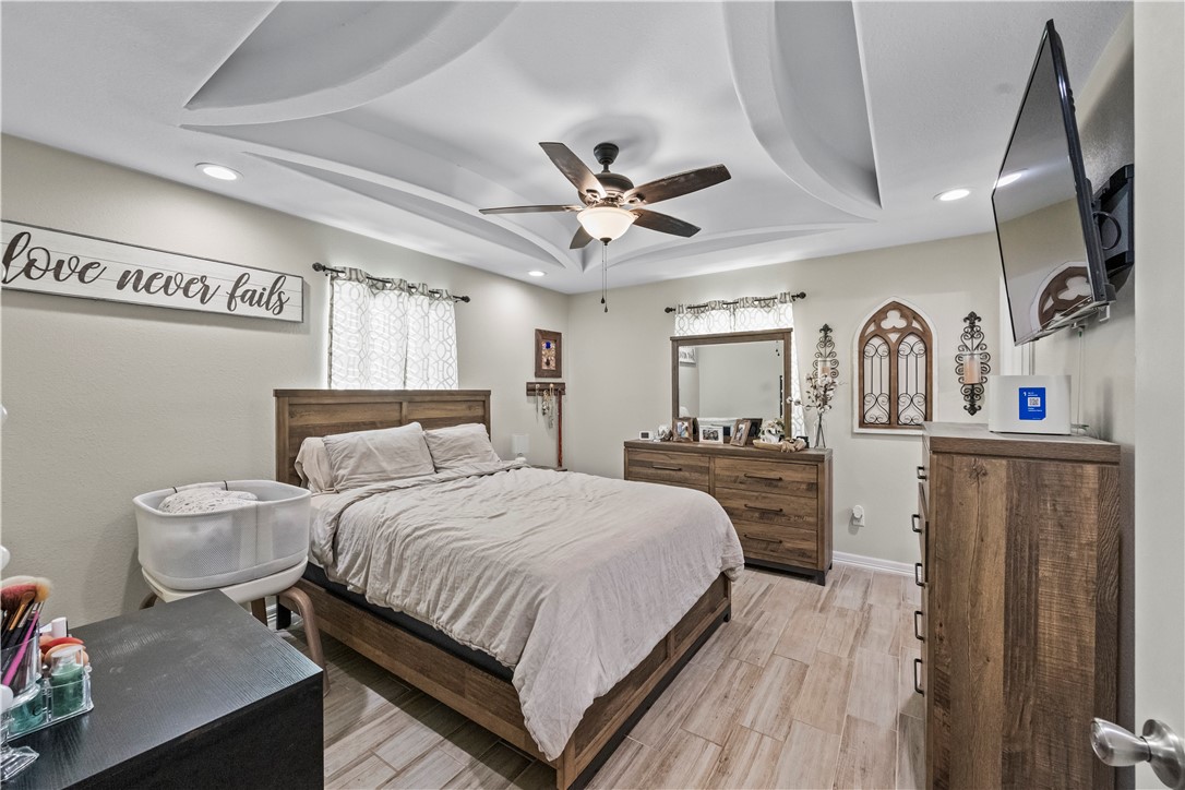 200 West 4th Street Alice, TX 78332 - Photo 9 of 19 a bedroom with a large bed and a chandelier