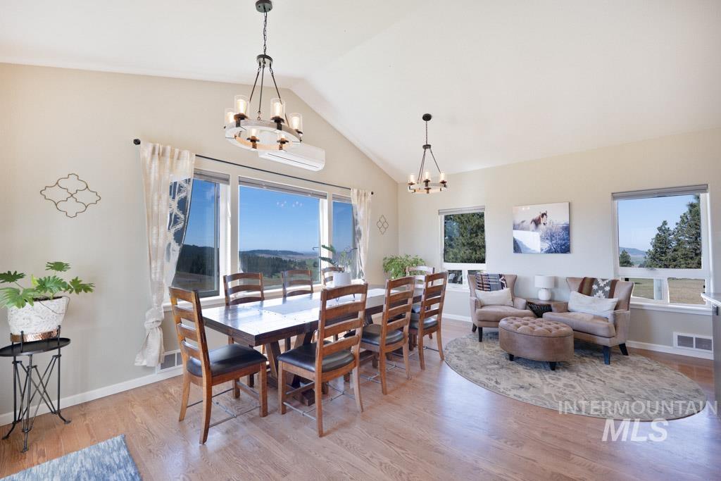 1049 Libey Road Viola, ID 83872 - Photo 12 of 43 Spacious living area featuring vaulted ceilings, wood-finish flooring, and expansive windows offering distant scenery
