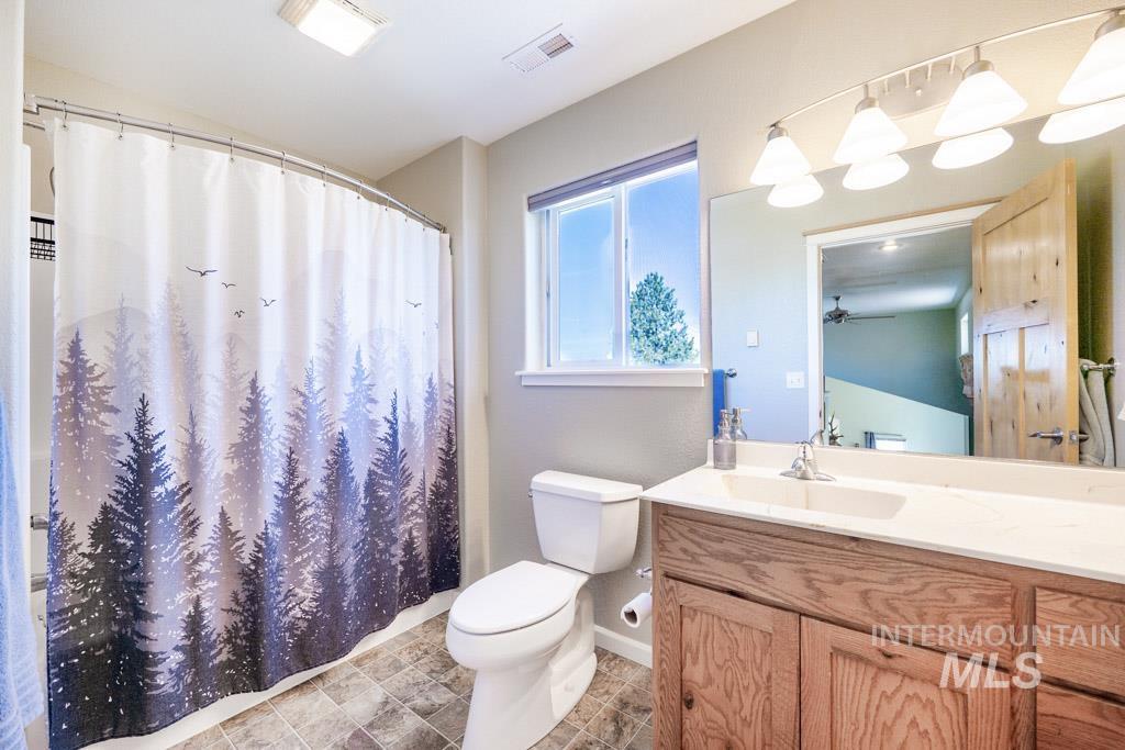 1049 Libey Road Viola, ID 83872 - Photo 19 of 43 Bathroom featuring a wood vanity with a white countertop, an integrated sink, and chrome fixtures