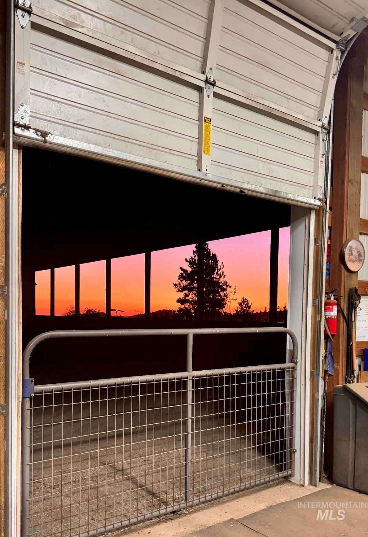 1049 Libey Road Viola, ID 83872 - Photo 34 of 43 Barn interior featuring a large overhead door, concrete flooring, and a metal grid gate