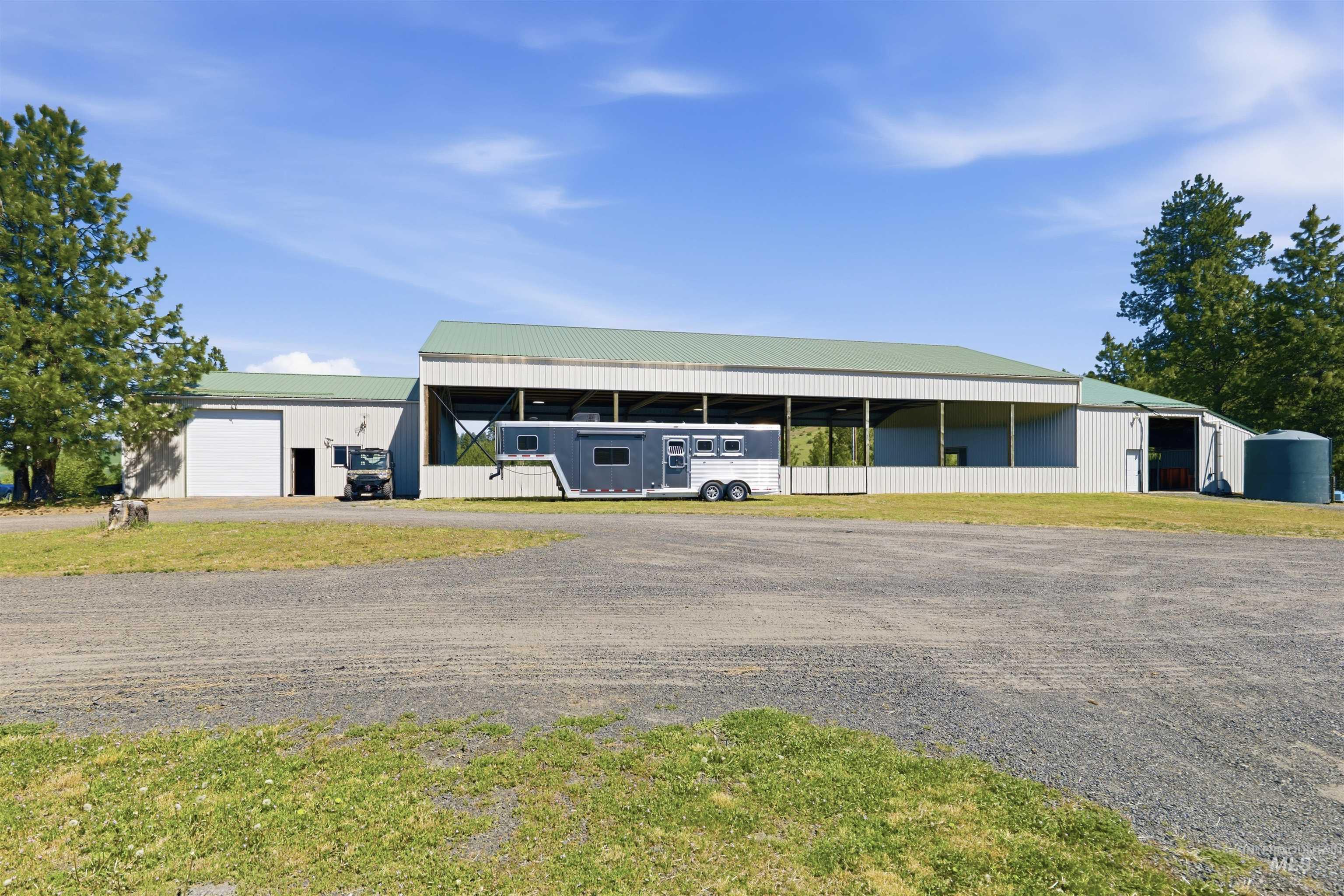 1049 Libey Road Viola, ID 83872 - Photo 4 of 43 Expansive outbuilding featuring a large covered open-air section, multiple enclosed storage areas, and a gravel surface in the foreground