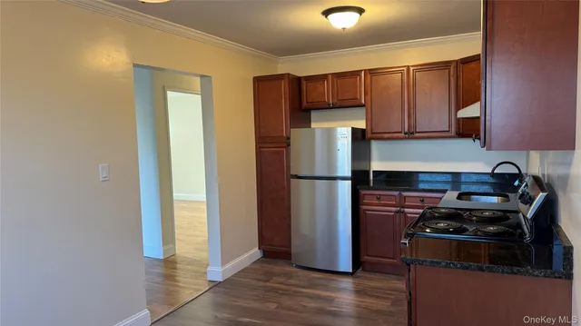 a kitchen with a refrigerator and a stove top oven
