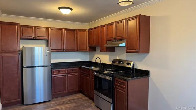 a kitchen with a refrigerator sink and cabinets