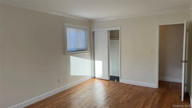 an empty room with wooden floor and closet
