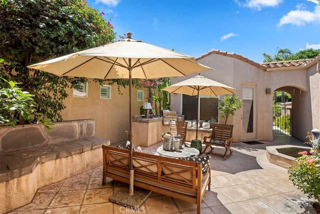 5614 Queen Palms Drive Riverside, CA 92506 - Photo 12 of 50 a patio with a table and chairs under an umbrella