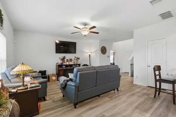a living room with furniture a flat screen tv and kitchen view