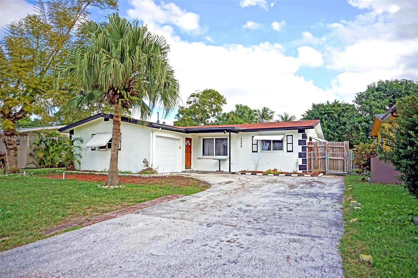 2496 North Pine Island Road Sunrise, FL 33322 - Photo 1 of 15 a house that has a tree in front of the house