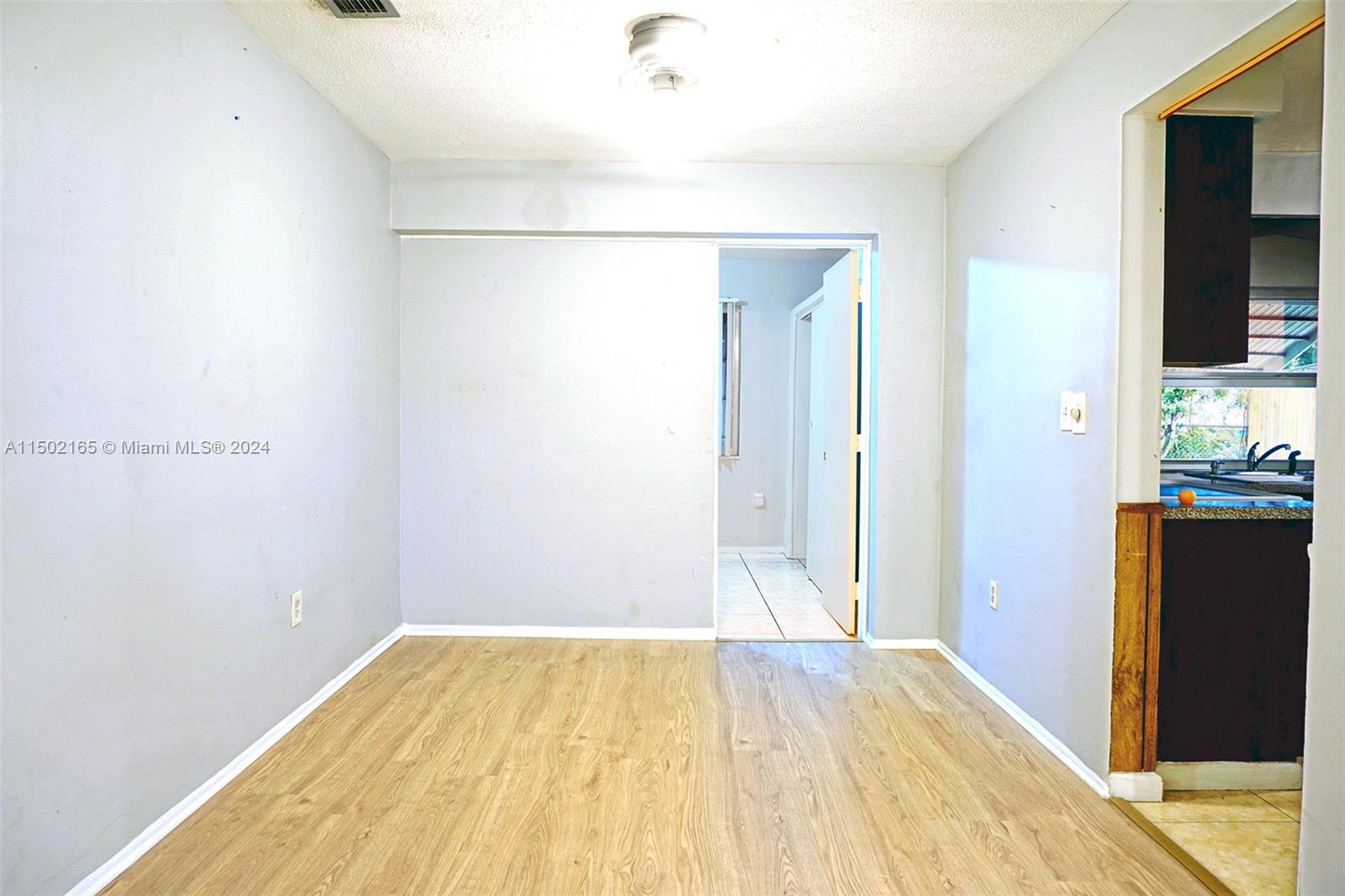 2496 North Pine Island Road Sunrise, FL 33322 - Photo 4 of 15 a bedroom with a bed and wooden floor