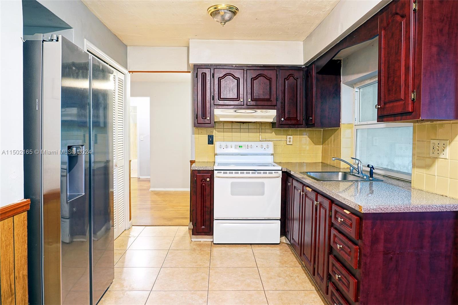 2496 North Pine Island Road Sunrise, FL 33322 - Photo 6 of 15 a kitchen with a stove top oven sink and cabinets