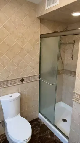 a white toilet sitting next to a bath tub and shower