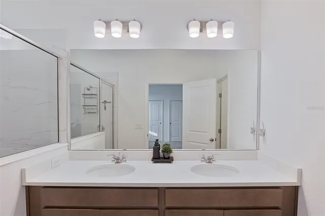 a bathroom with double vanity sinks and a mirror