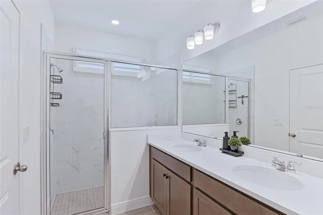 a bathroom with a shower sink vanity and mirror