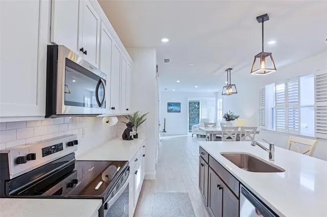 a kitchen that has a sink a stove and a wooden floor