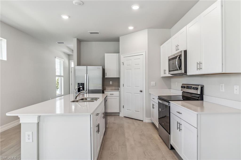 826 Friendship Circle LaBelle, FL 33935 - Photo 12 of 19 a kitchen with stainless steel appliances a stove refrigerator sink and cabinets