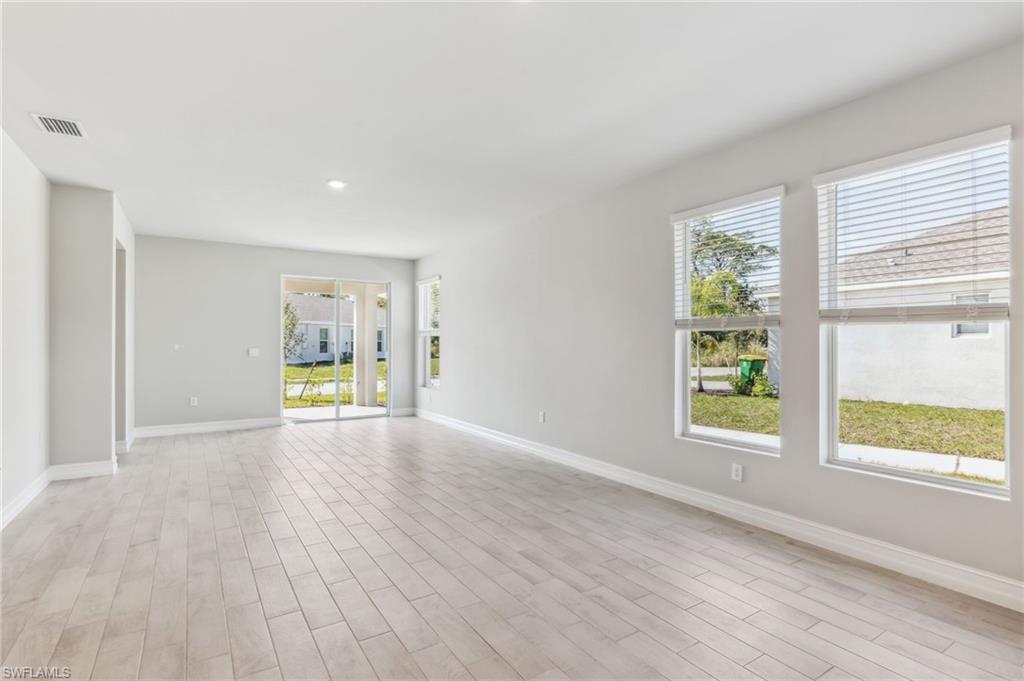 826 Friendship Circle LaBelle, FL 33935 - Photo 15 of 19 an empty room with wooden floor and windows