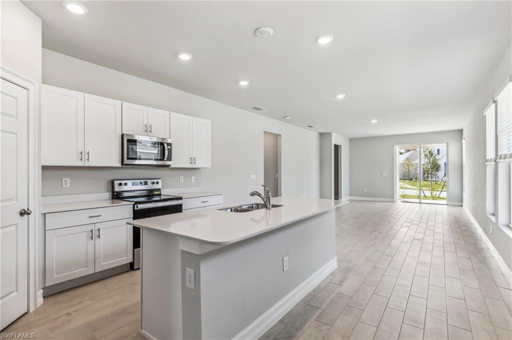 826 Friendship Circle LaBelle, FL 33935 - Photo 8 of 19 a kitchen with stainless steel appliances granite countertop a sink a stove a refrigerator and cabinets