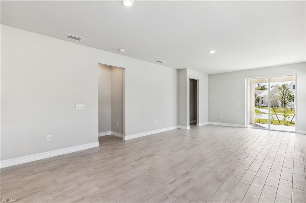 826 Friendship Circle LaBelle, FL 33935 - Photo 10 of 19 an empty room with wooden floor and windows