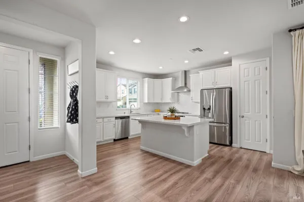 a kitchen with a refrigerator and a stove top oven