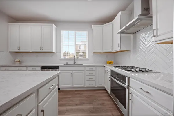 a kitchen with cabinets appliances a sink and a window