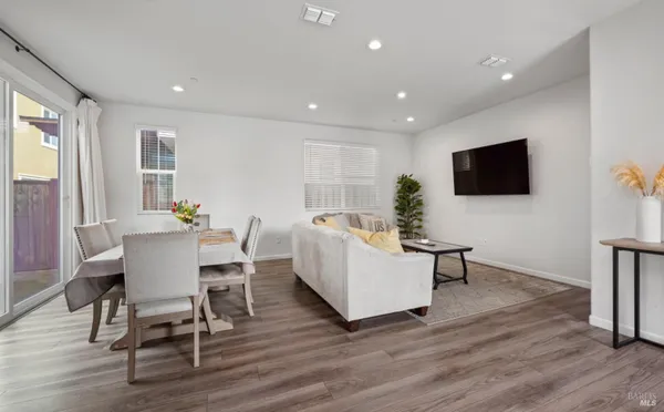 a living room with furniture a flat screen tv and wooden floor