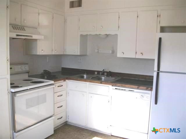702 North 1st Street, Unit 3 Copperas Cove, TX 76522 - Photo 2 of 7 a kitchen with granite countertop white cabinets and white appliances