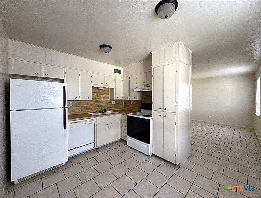 702 North 1st Street, Unit 5 Copperas Cove, TX 76522 - Photo 5 of 8 a kitchen with a refrigerator a stove top oven and cabinets