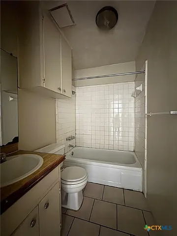 a bathroom with a granite countertop sink a toilet a mirror and shower