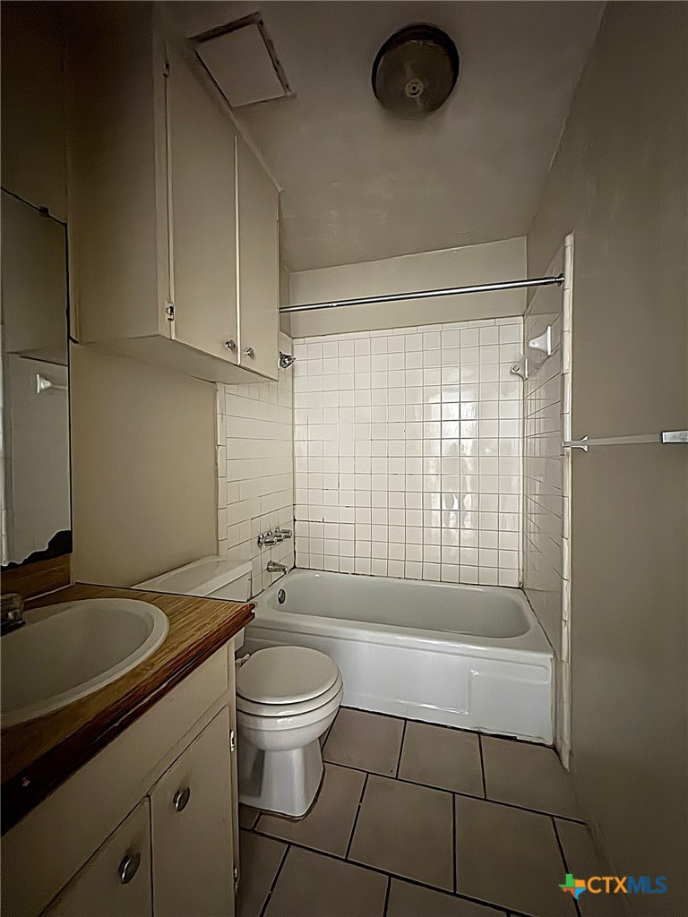 702 North 1st Street, Unit 3 Copperas Cove, TX 76522 - Photo 7 of 7 a bathroom with a granite countertop sink a toilet a mirror and shower