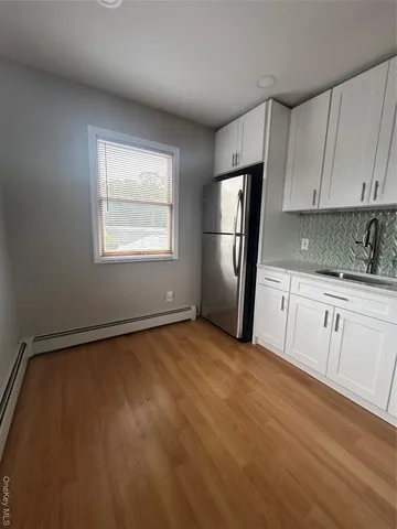 a view of a kitchen with wooden floor and electronic appliances
