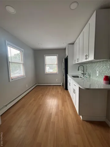 a kitchen with granite countertop wooden floors a sink and cabinets