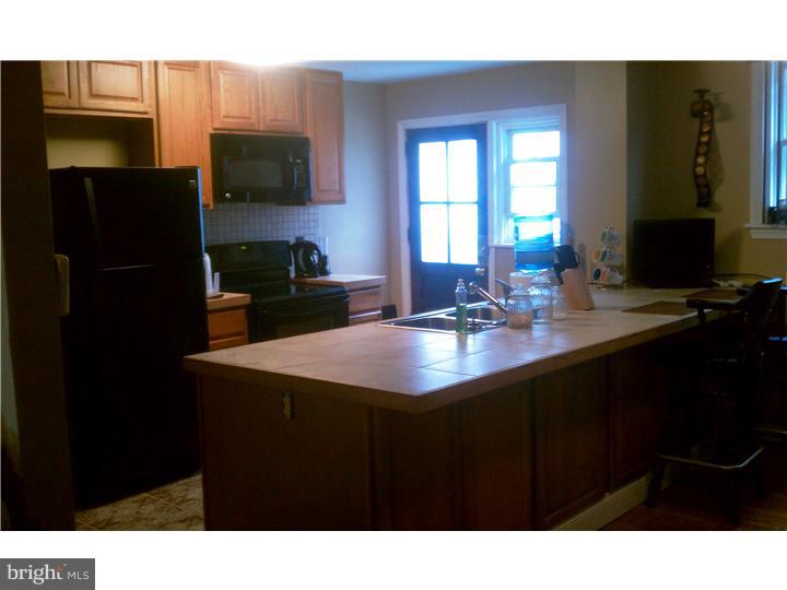 256 Glendale Road Upper Darby, PA 19082 - Photo 12 of 13 a kitchen with a sink a microwave a refrigerator and cabinets