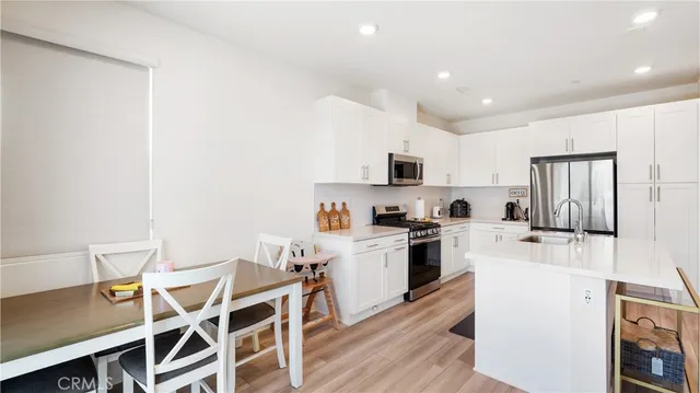 a kitchen with a table chairs microwave and cabinets