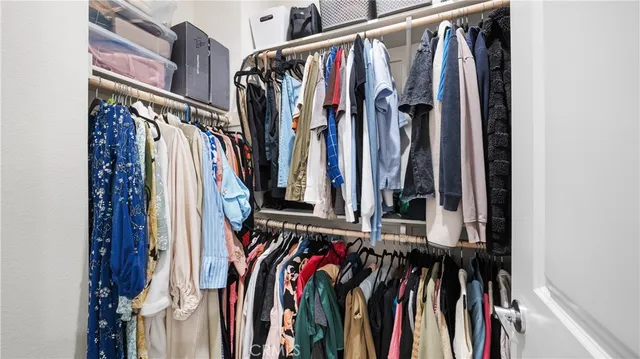 a view of walk in closet with clothes