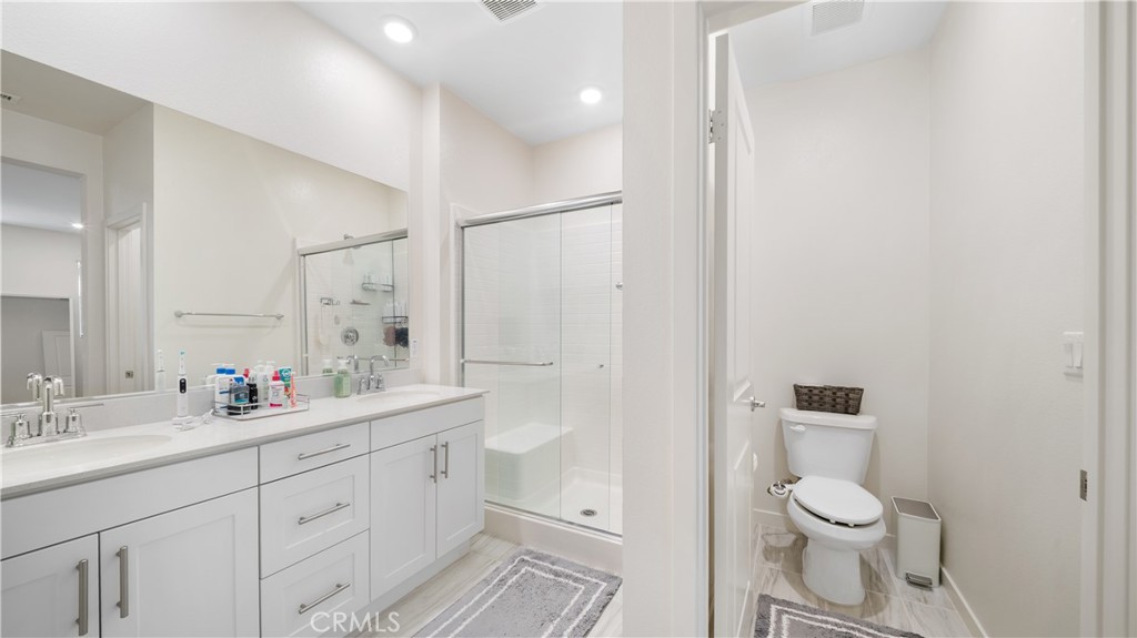 3610 East Pollock Street, Unit 4 Ontario, CA 91761 - Photo 23 of 47 a bathroom with a double vanity sink toilet mirror and shower