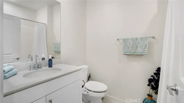 a bathroom with a granite countertop sink a toilet and a mirror