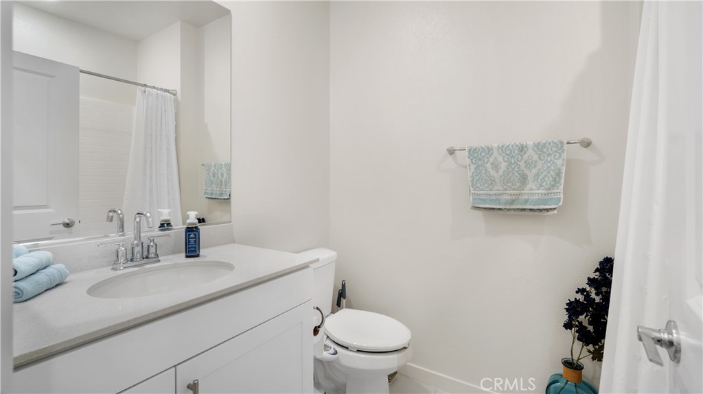 3610 East Pollock Street, Unit 4 Ontario, CA 91761 - Photo 28 of 47 a bathroom with a granite countertop sink a toilet and a mirror