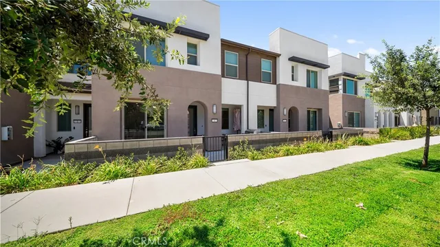 a view of a white house with a yard and plants