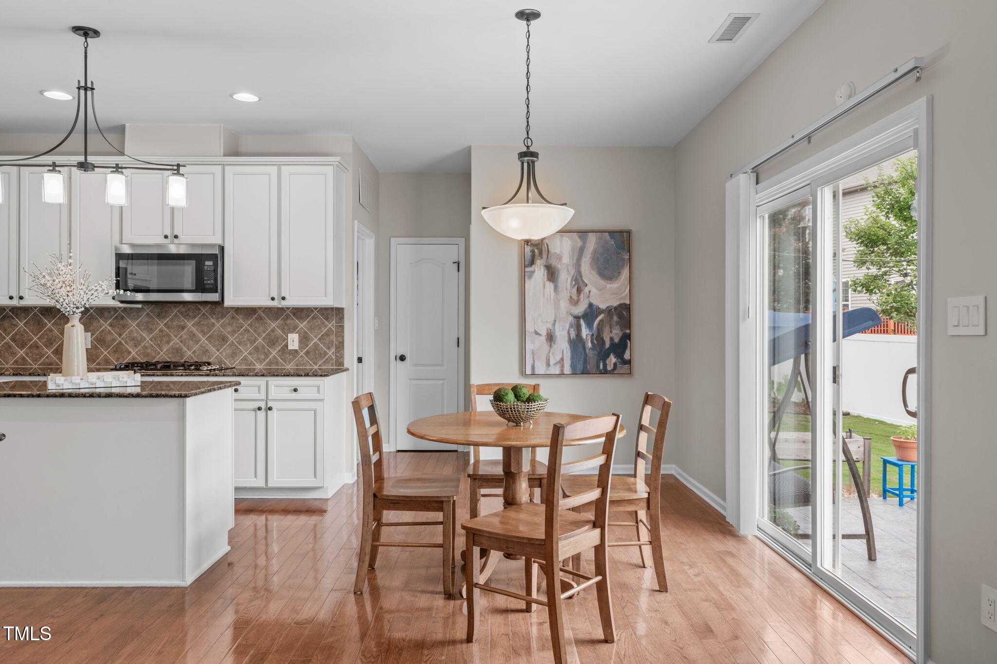 1909 Ferntree Court Morrisville, NC 27560 - Photo 13 of 38 a kitchen with stainless steel appliances granite countertop a stove a sink a microwave a dining table and chairs