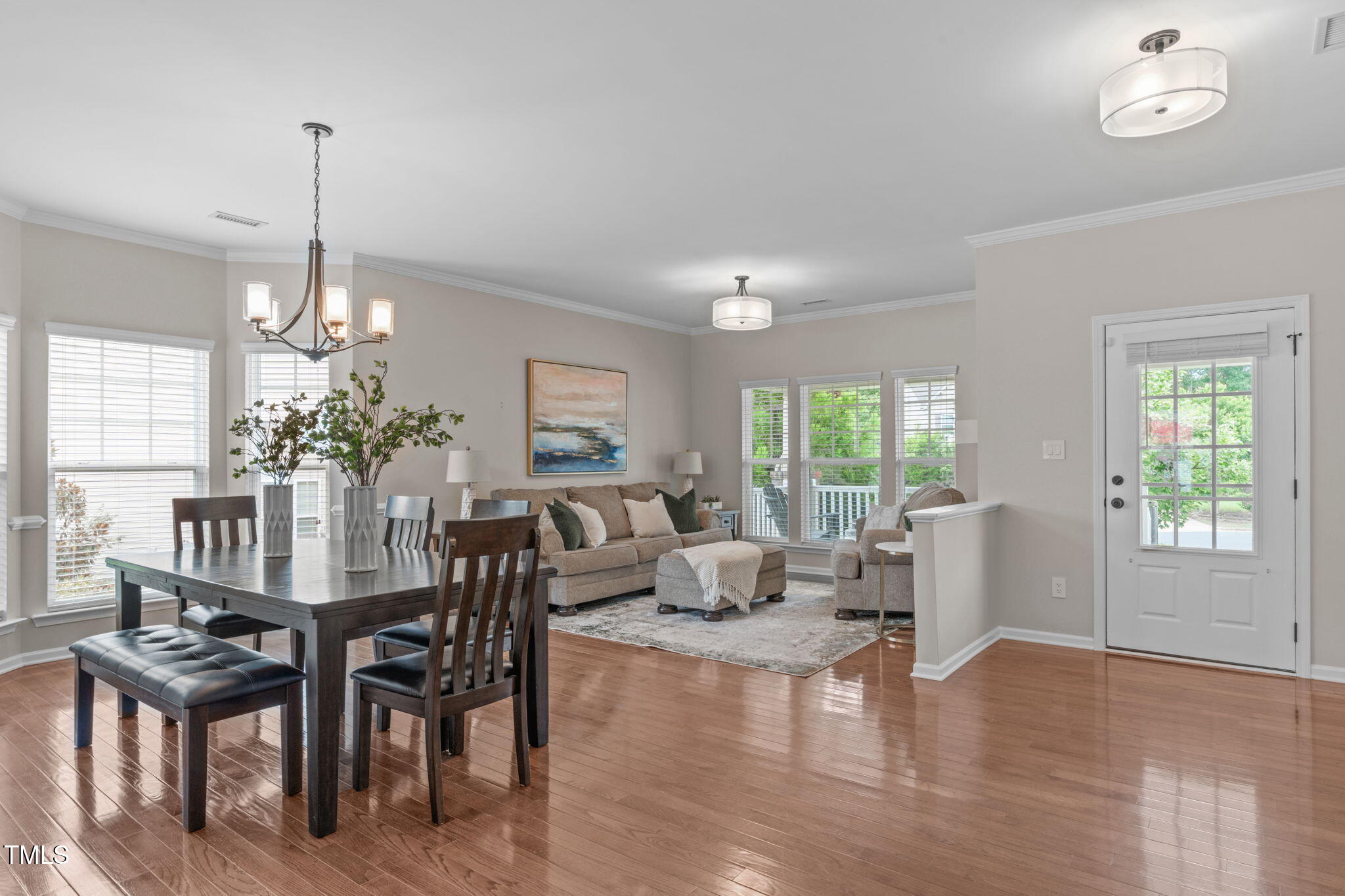 1909 Ferntree Court Morrisville, NC 27560 - Photo 9 of 38 a dining room with furniture a chandelier and wooden floor